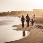 unknown persons walking on seashore