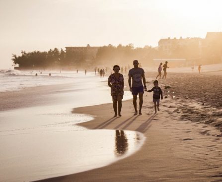 unknown persons walking on seashore