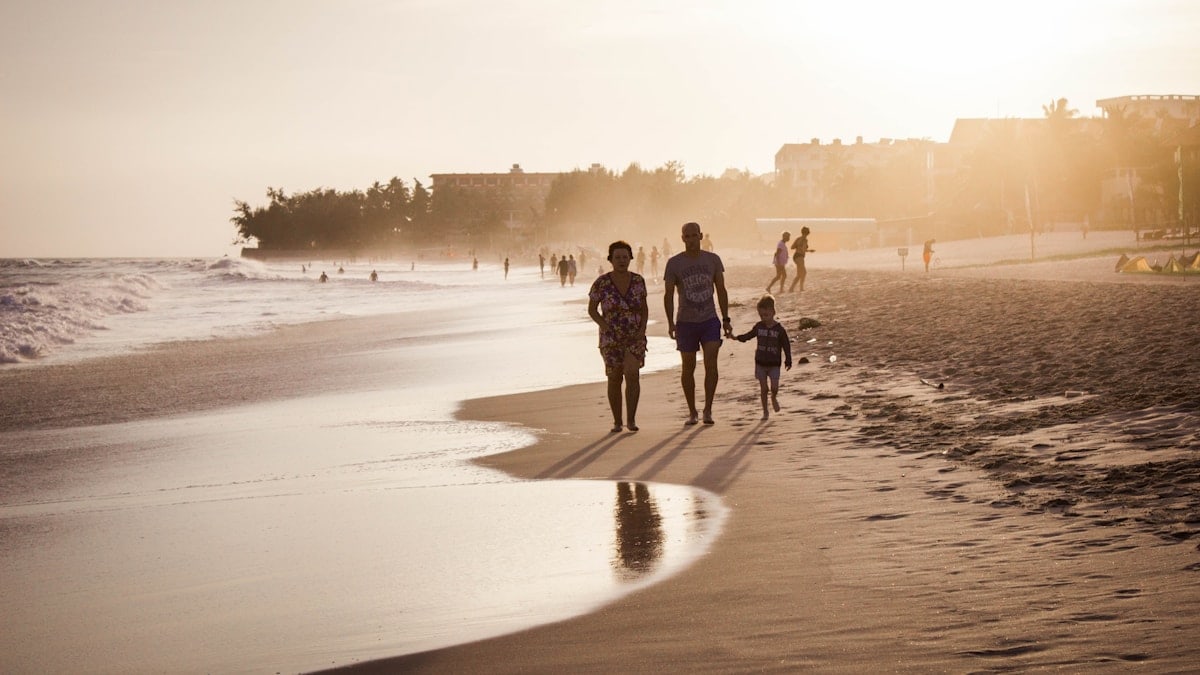 unknown persons walking on seashore
